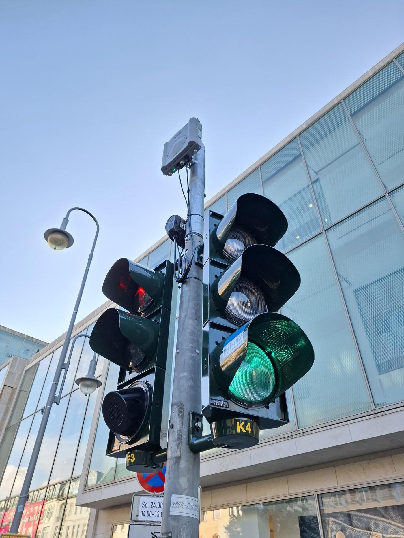 Ein Ampel-Signalgeber in der Schloßstraße in Berlin-Steglitz. Am Mast ist auch eine sog. Roadside Unit befestigt, ein digitales Funkmodul.