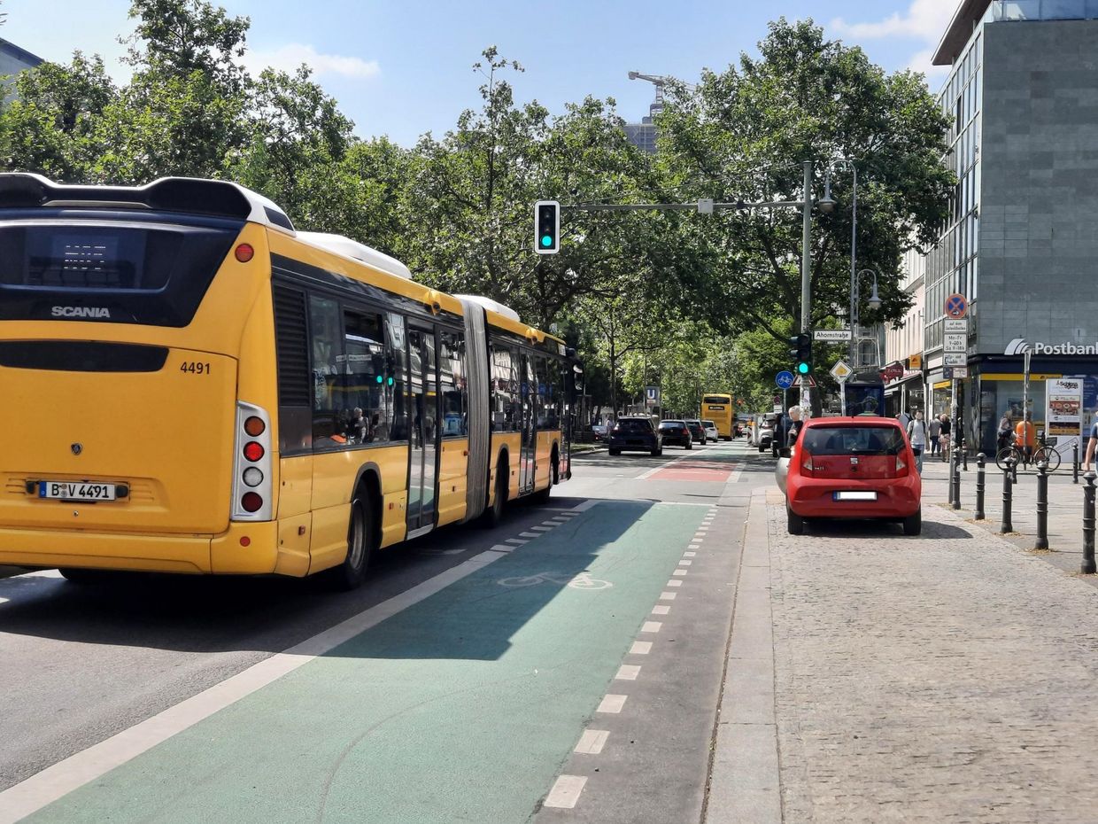 Ein Bus der BVG fährt auf der Schloßstraße in Berlin-Steglitz auf eine Ampelkreuzung zu. Die Ampel zeigt Grün.